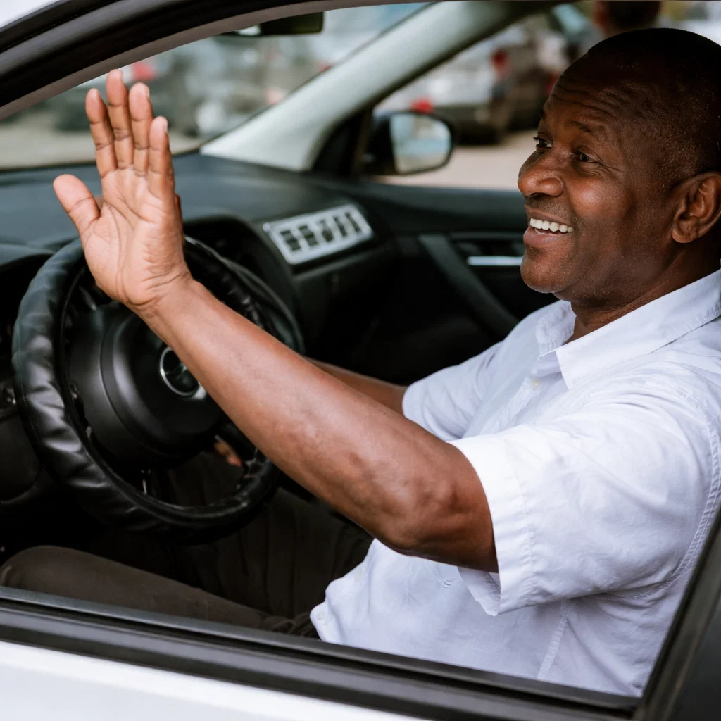 Local driver waving from inside a car